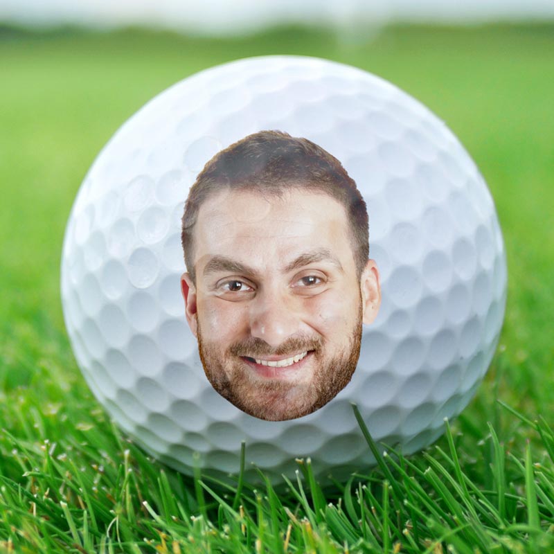 Custom golf ball with a personalized face on green grass, "If found return to this guy" gift for golf lover.